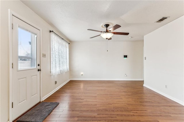 foyer entrance with ceiling fan, hardwood / wood-style floors, and a textured ceiling