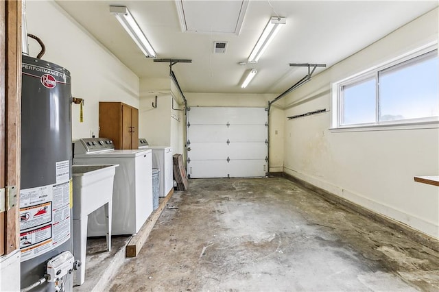 garage featuring water heater and separate washer and dryer