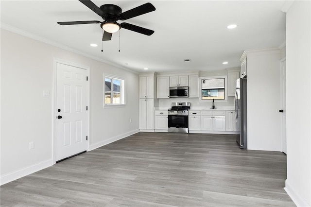 unfurnished living room featuring crown molding, ceiling fan, and light wood-type flooring