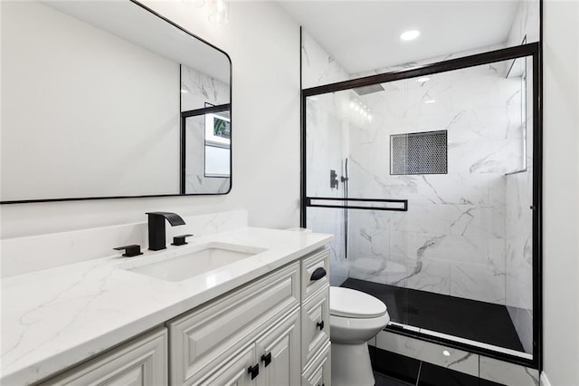 bathroom featuring vanity, toilet, and a shower with door