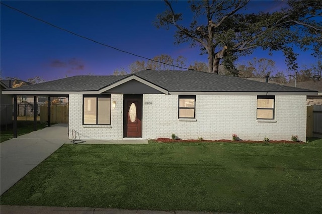 single story home with a lawn and a carport