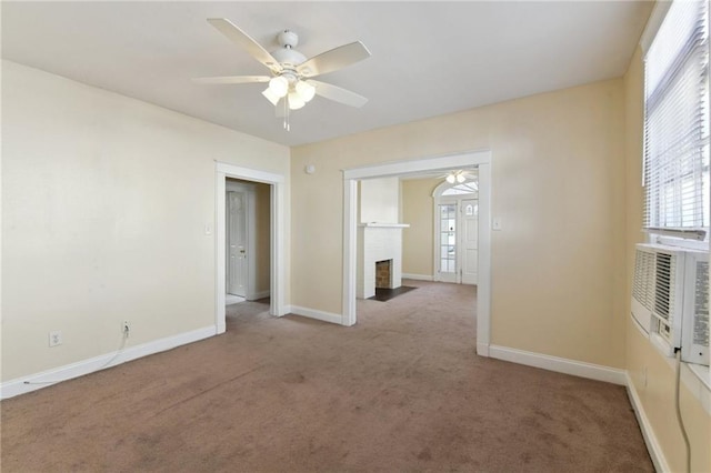 empty room with ceiling fan, carpet flooring, and a fireplace