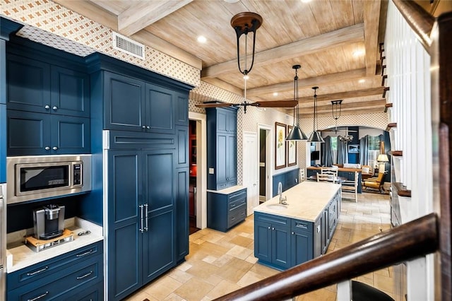 2425 Coliseum St, New Orleans, LA 70130 - kitchen with beam ceiling, stainless steel microwave, blue cabinetry, and wood ceiling