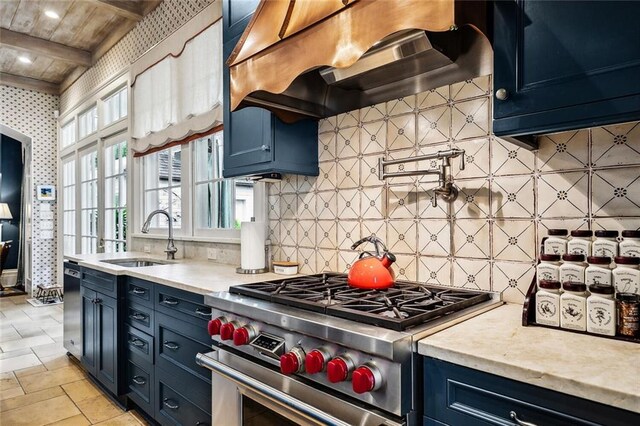 2425 Coliseum St, New Orleans, LA 70130 - kitchen featuring stainless steel range, a sink, dishwashing machine, blue cabinets, and extractor fan