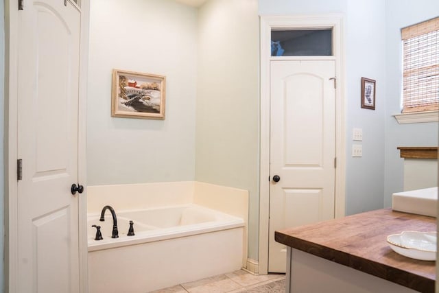 bathroom with vanity, tile patterned flooring, and a bathtub