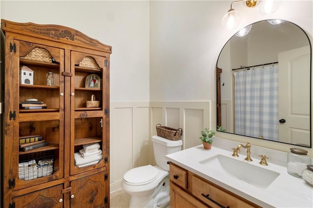 bathroom featuring vanity, walk in shower, and toilet