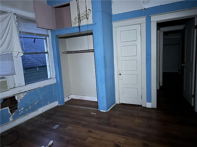 unfurnished bedroom with dark hardwood / wood-style flooring and a closet