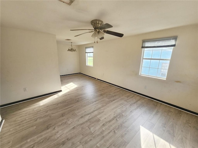 empty room featuring baseboards, a ceiling fan, and wood finished floors