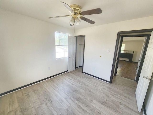 unfurnished bedroom with ceiling fan, baseboards, light wood-style floors, and a closet
