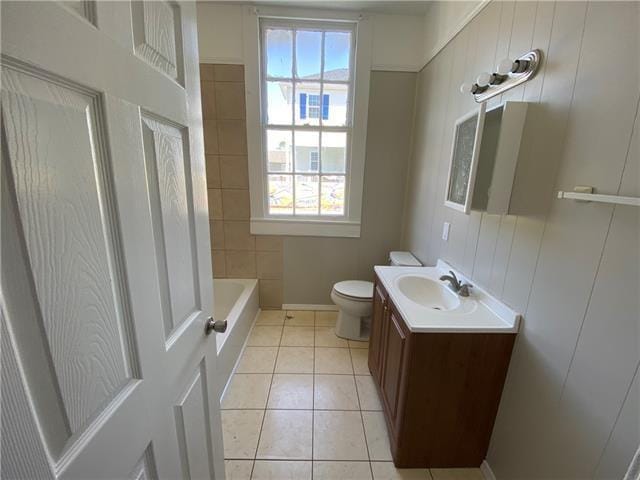 bathroom featuring vanity, toilet, tile patterned flooring, and a wealth of natural light