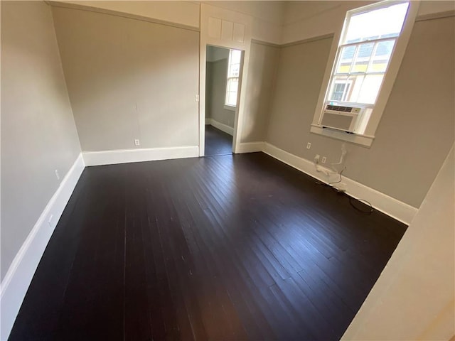 unfurnished room featuring cooling unit and dark hardwood / wood-style floors