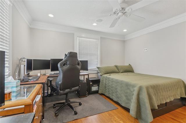 bedroom with ceiling fan, ornamental molding, and hardwood / wood-style floors