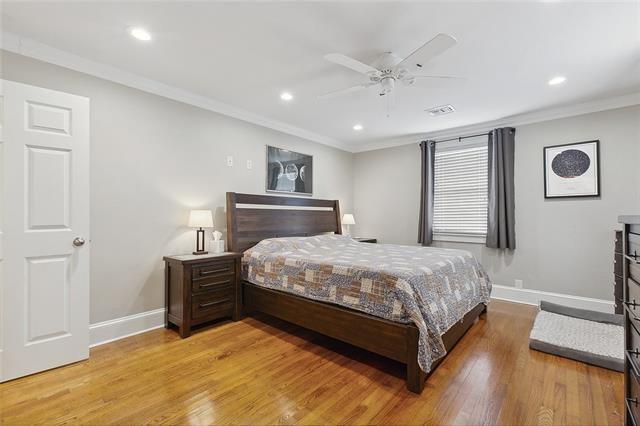 bedroom featuring ornamental molding, ceiling fan, and light hardwood / wood-style flooring