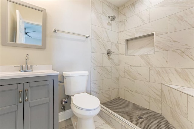 bathroom featuring vanity, toilet, and tiled shower