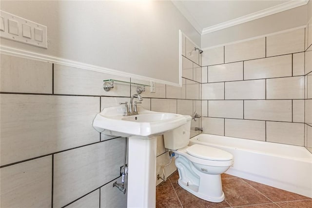 bathroom featuring tile walls, tiled shower / bath combo, toilet, crown molding, and tile patterned floors