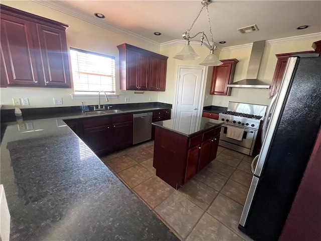 kitchen with appliances with stainless steel finishes, sink, hanging light fixtures, crown molding, and wall chimney range hood