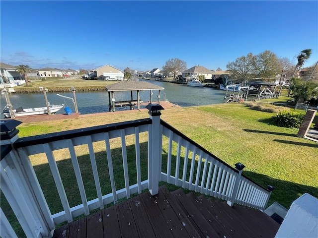 wooden terrace featuring a lawn, a boat dock, and a water view