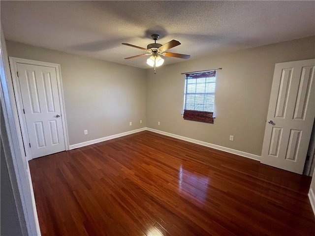 unfurnished bedroom with ceiling fan, dark wood-type flooring, and a textured ceiling