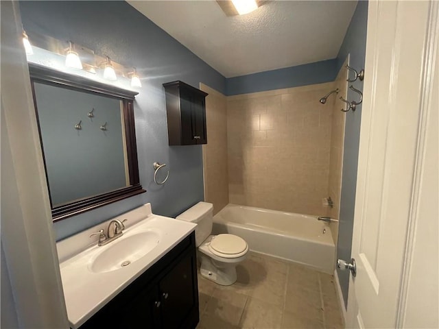 full bathroom featuring tiled shower / bath combo, vanity, tile patterned flooring, toilet, and a textured ceiling