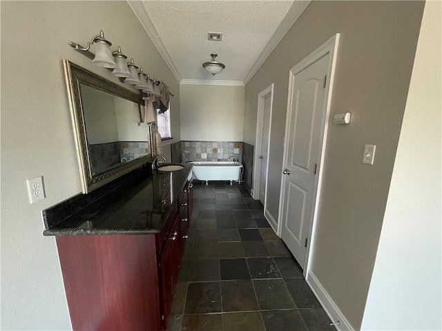 hall with dark tile patterned floors, crown molding, sink, and a textured ceiling