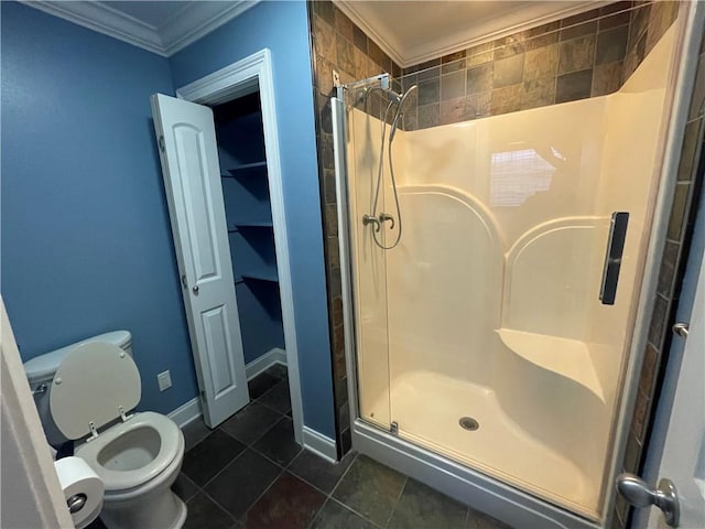 bathroom featuring tile patterned floors, ornamental molding, toilet, and a shower with door