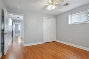 unfurnished bedroom featuring ceiling fan, light wood-type flooring, and a closet