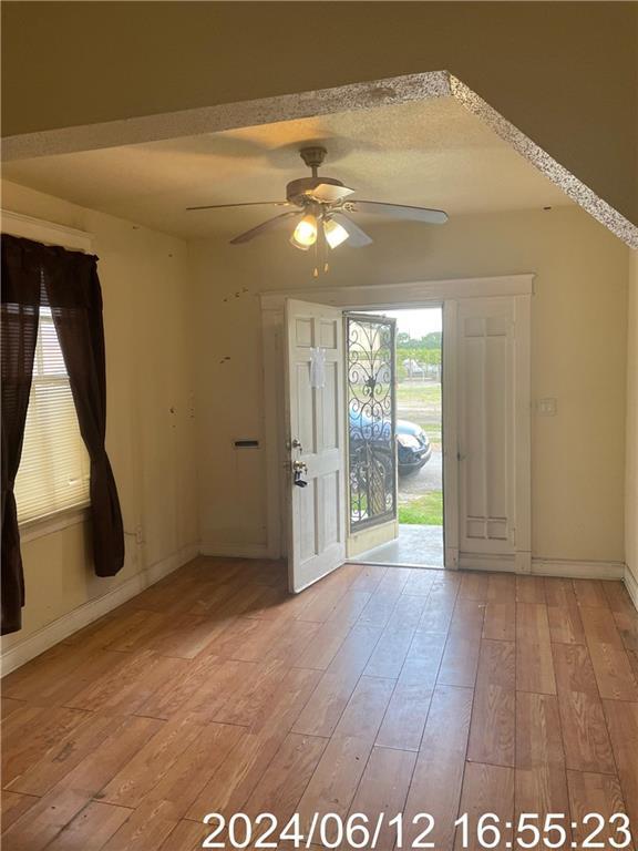 entryway featuring light wood-type flooring, baseboards, and a ceiling fan