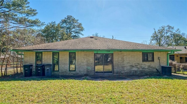 back of property featuring a lawn and central air condition unit