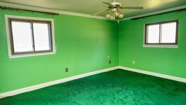 carpeted spare room with crown molding, ceiling fan, and a healthy amount of sunlight