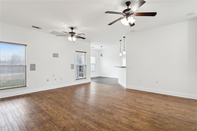 unfurnished living room featuring dark hardwood / wood-style flooring and ceiling fan