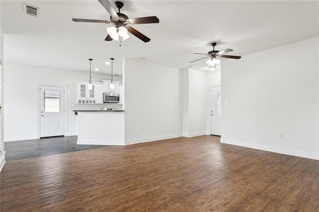 unfurnished living room with ceiling fan and dark hardwood / wood-style flooring