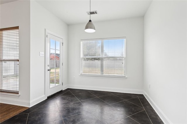 unfurnished dining area with dark tile patterned floors