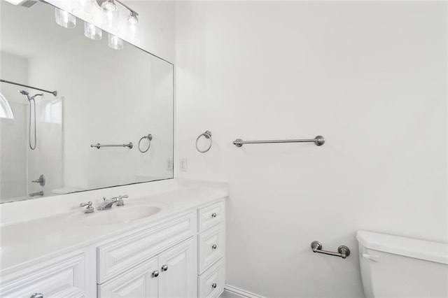 bathroom featuring vanity, a shower, and toilet