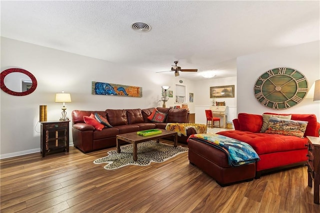 living room with ceiling fan, hardwood / wood-style flooring, and a textured ceiling