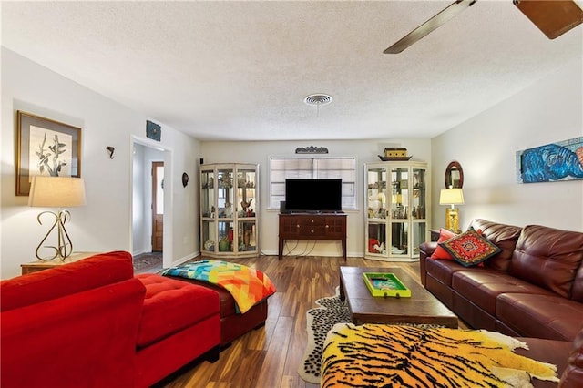 living room with dark hardwood / wood-style flooring and a textured ceiling