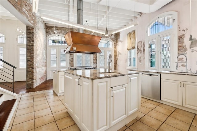 kitchen with island exhaust hood, stainless steel dishwasher, sink, and a kitchen island with sink