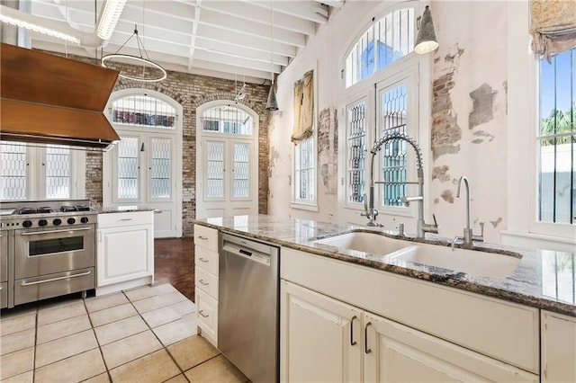 kitchen with appliances with stainless steel finishes, stone countertops, sink, exhaust hood, and french doors