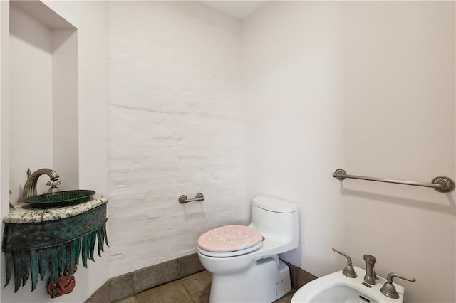 bathroom with a bidet, tile patterned flooring, and toilet