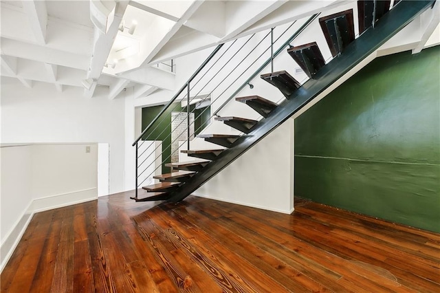 staircase featuring hardwood / wood-style flooring and beam ceiling