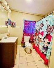 bathroom featuring tile patterned floors, vanity, and toilet