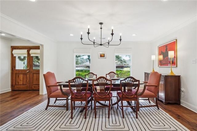 dining space featuring dark hardwood / wood-style flooring, a notable chandelier, and crown molding