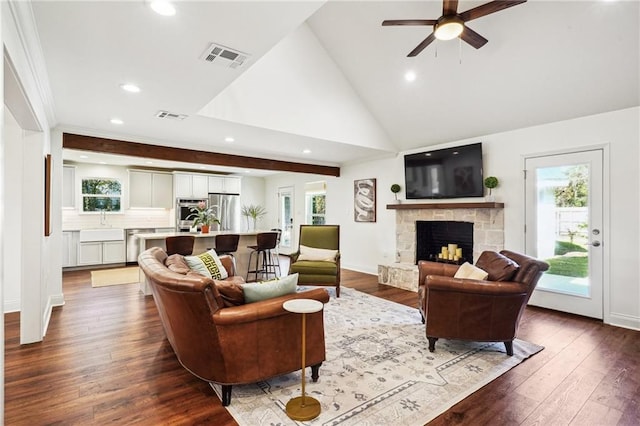 living room featuring ceiling fan, high vaulted ceiling, a fireplace, and dark hardwood / wood-style flooring