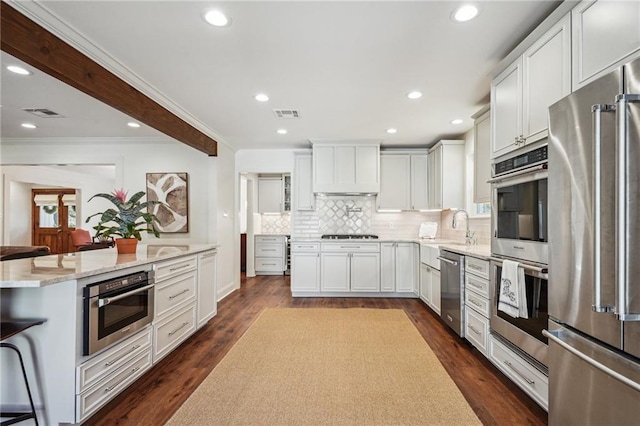 kitchen with white cabinetry, stainless steel appliances, dark hardwood / wood-style flooring, and decorative backsplash