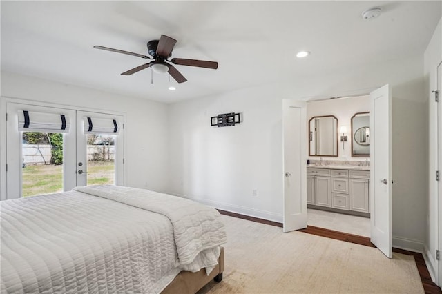 bedroom featuring ensuite bathroom, access to outside, light wood-type flooring, and french doors