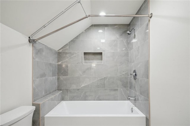 bathroom with toilet and tiled shower / bath combo