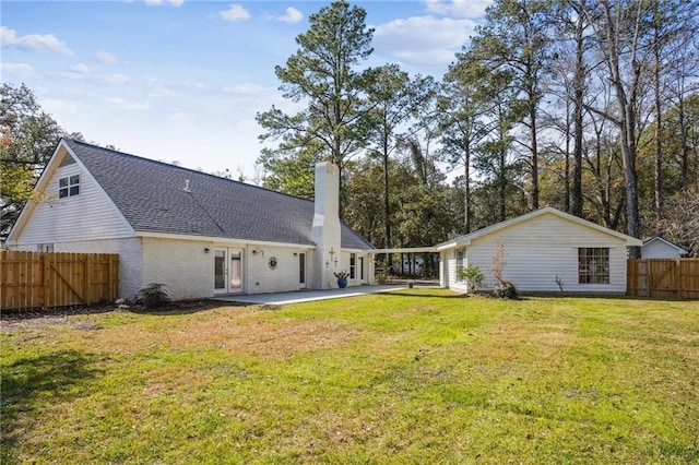 rear view of property featuring a lawn and a patio area