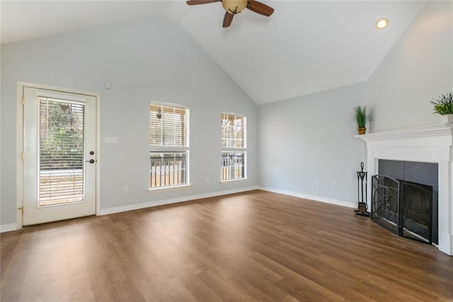 unfurnished living room featuring high vaulted ceiling, dark wood-type flooring, a wealth of natural light, and ceiling fan