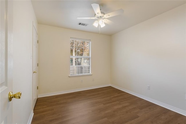 spare room featuring dark wood-type flooring and ceiling fan