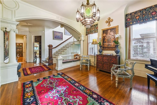 entrance foyer featuring an inviting chandelier, hardwood / wood-style floors, and decorative columns