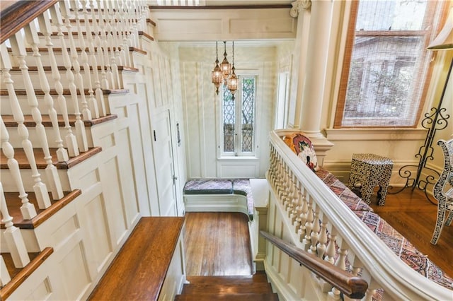 interior space featuring hardwood / wood-style floors, a notable chandelier, and ornate columns